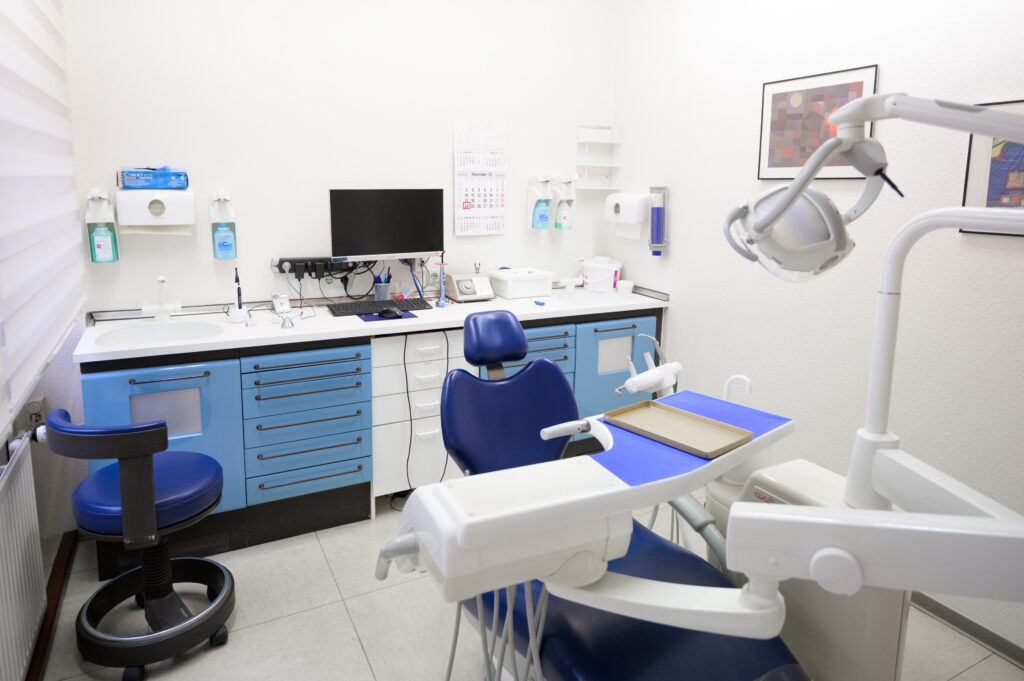 Helles, modernes Behandlungszimmer mit Zahnbehandlungsstuhl in der Zahnarztpraxis Amayri in Duisburg